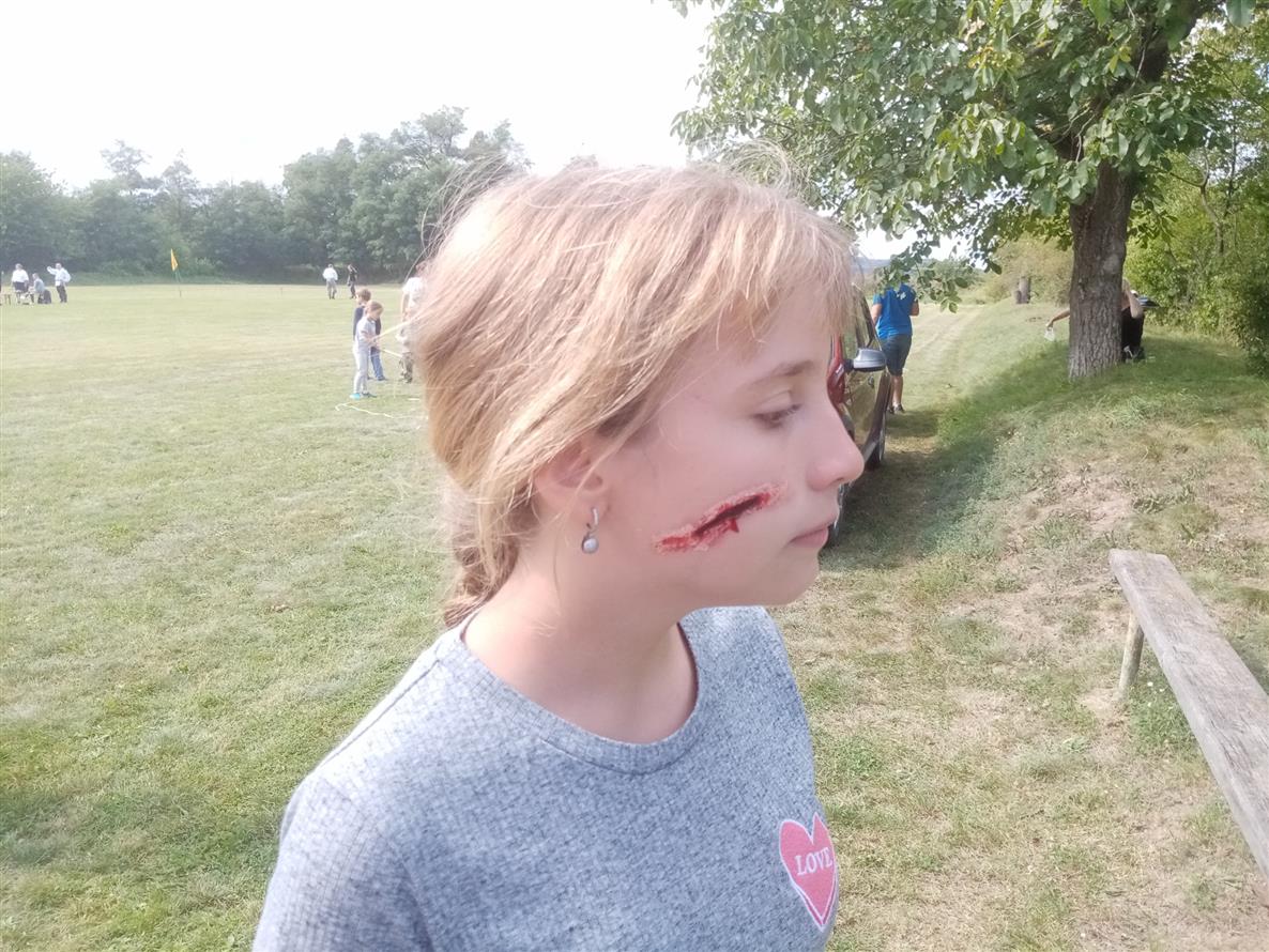 Dívka s namalovaným zraněním na obličeji